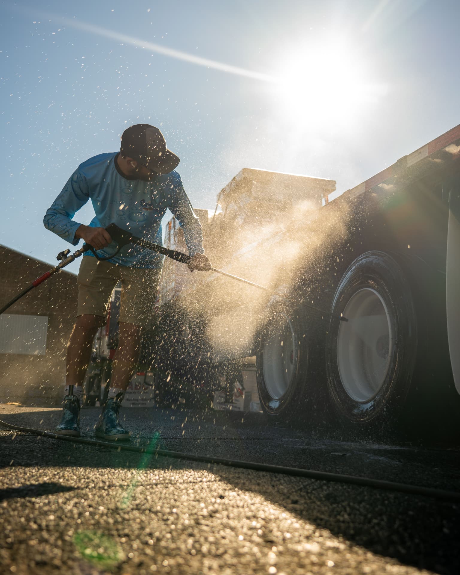 Cayne's Power Washing technician washing a commercial box truck in a fleet yard
